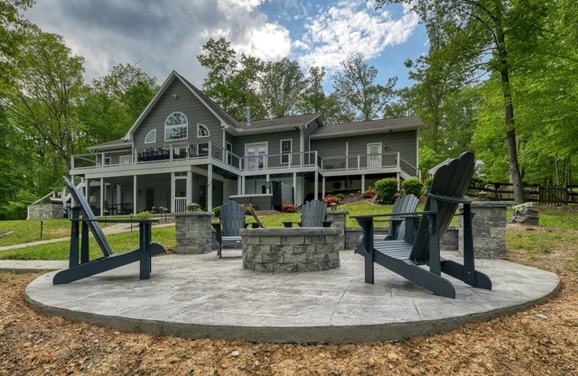 Sprawling waterfront home with a boat launch, kayaks, game room, and hot tub