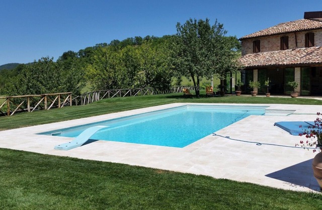 villa de piedra con piscina privada, rodeada del parque de Frasassi.