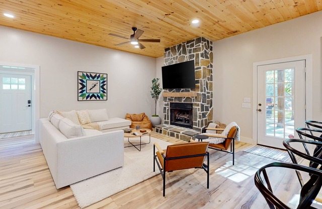 Stunning dog-friendly cottage with riverfront patio, hot tub, fire pit, & views