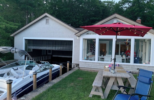 Stunning lakefront home with a boathouse, private dock, firepit and lake views