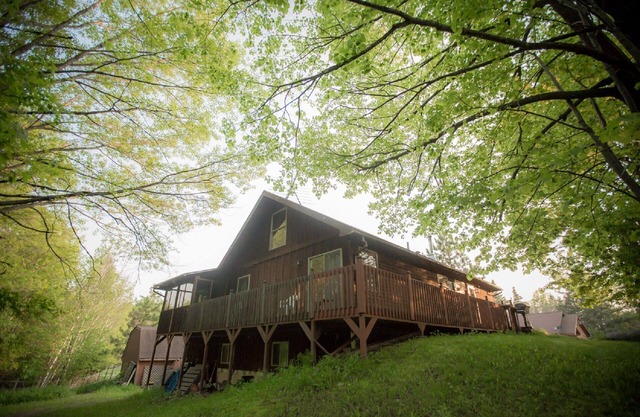 The Cedar House se encuentra en el bosque, rodeado de terrazas y porches.