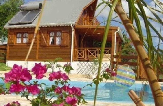 El encanto de un bungalow de madera frente a la laguna en un jardín con piscina