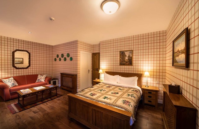 The wooden floors, vintage furniture, and tartan accents create a comfy room