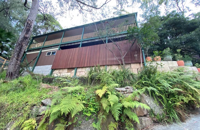 Treetops retreat - pole house set against a sandstone rock face in the tree tops