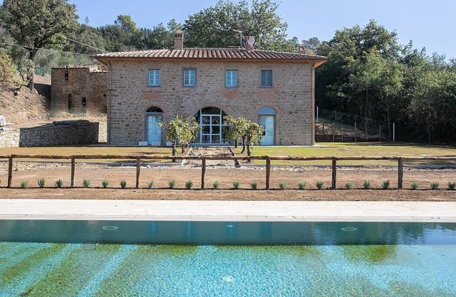 Villa Evarne: Una elegante y acogedora villa de dos pisos rodeada de vegetación.