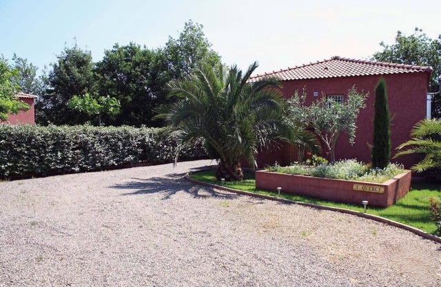 Villa en residencia privada junto al mar en parque sombreado.