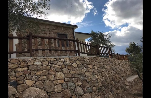 VILLA en piedra sarda rodeada de vegetación. Terraza panorámica, barbacoa y zona de relax.