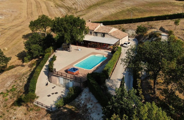Villa con piscina privada y jacuzzi en una posición panorámica.