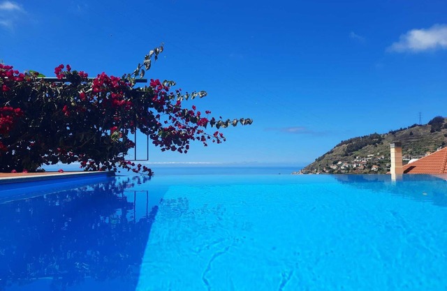 Villa con piscina infinita y sala de juegos con vistas al mar.