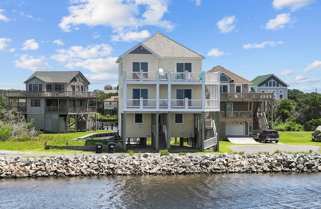 Waterfront home with boat dock, shared pool, & balcony with ocean view