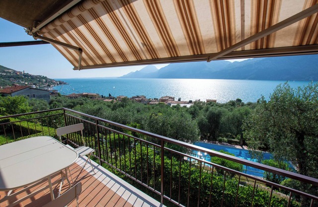 maravilloso balcón en el lago con hermosa piscina y jardín entre palmeras y olivos