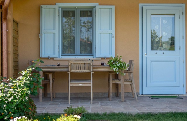 Casita de madera con porche y jardín
