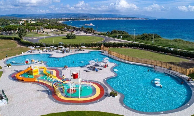 Fertilia Chalet De Esquí | Un versátil campamento familiar en Cerdeña, justo sobre el agua azul del mar.