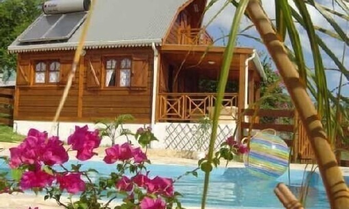La Saline Les Bains Cabina | El encanto de un bungalow de madera frente a la laguna en un jardín con piscina
