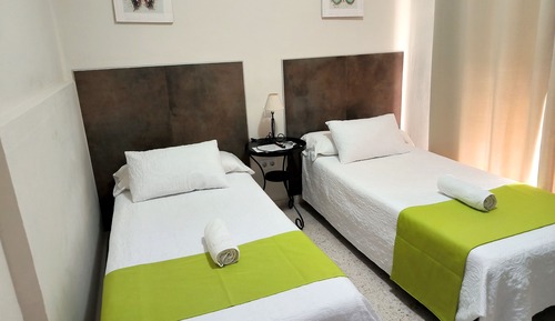 Habitación con 2 camas individuales, baño compartido, vistas a la ciudad