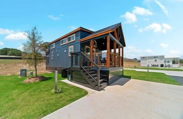 Texas Farmhouse-Style Blue Tiny Home Features Dual Porches, Multi-Level Sleeping Areas, and Full Kit
